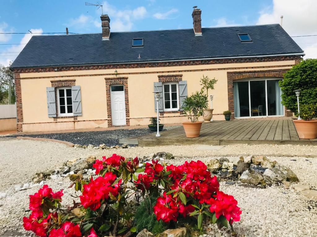 a house with red flowers in front of it at Gîte de la Perdrix 