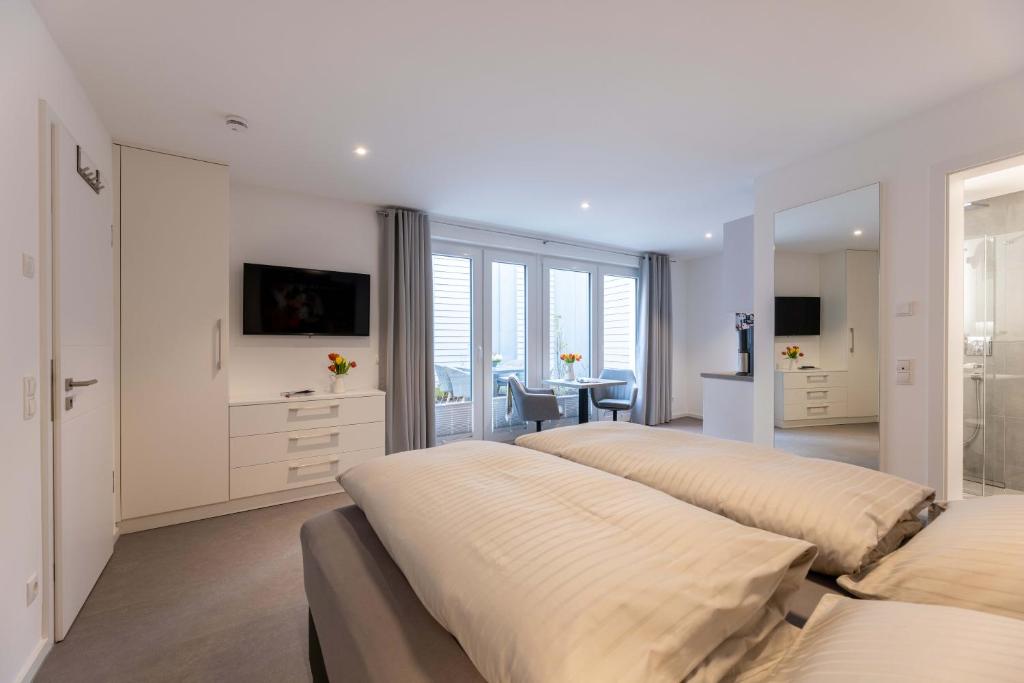 a bedroom with three beds and a desk and a table at Haus Andersen Apartment ZWEI in Norderney