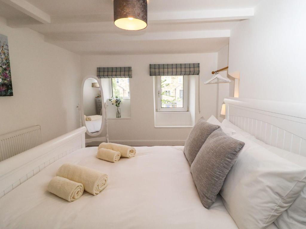 ein Schlafzimmer mit einem großen weißen Bett mit zwei Kissen in der Unterkunft Hideaway Cottage in Barnoldswick