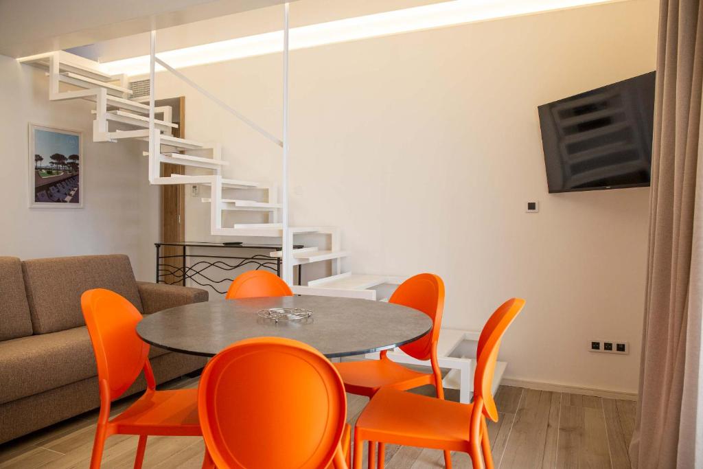 jadalnia ze stołem i pomarańczowymi krzesłami w obiekcie Résidence du Lido w Argelès-sur-Mer