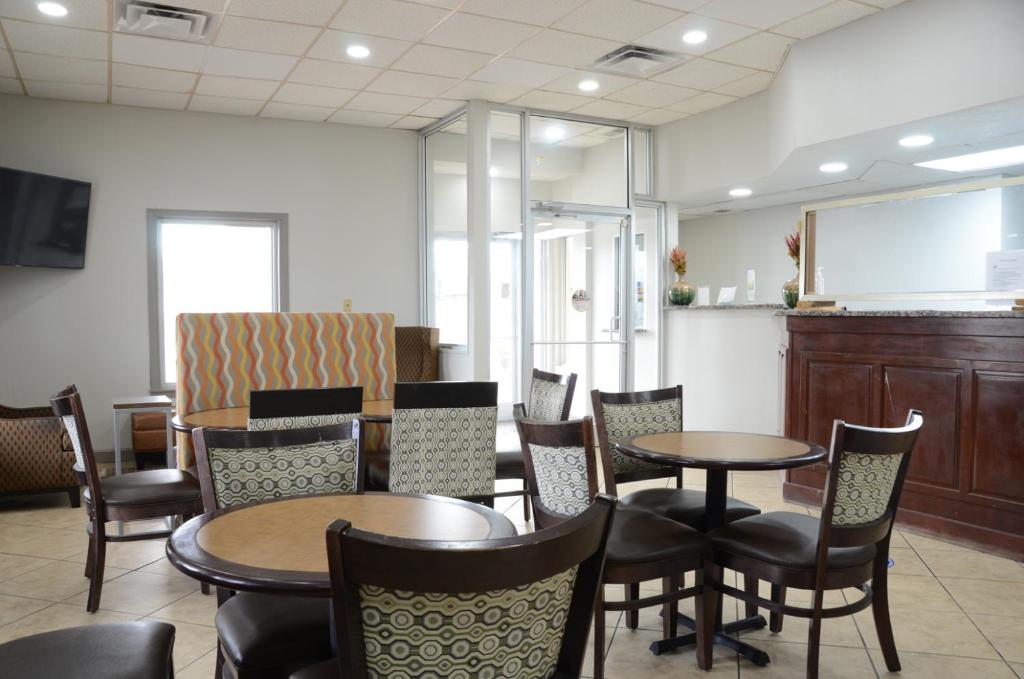 a restaurant with tables and chairs and a counter at Quality Inn & Suites Covington in Covington
