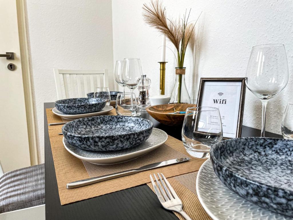 stół z niebiesko-białymi talerzami i kieliszkami do wina w obiekcie Sweet Dream in The City w Bremie