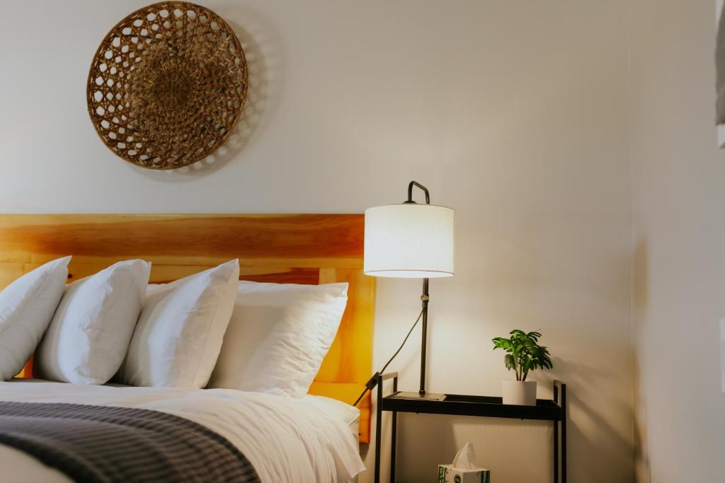 a bedroom with a bed with white pillows and a lamp at North Coast Place in Marquette