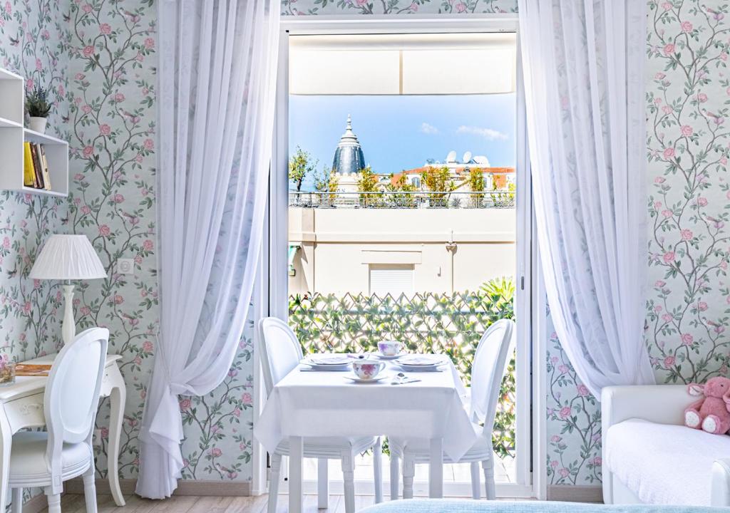 カンヌにあるPalais Miramar Imperial Croisetteのダイニングルーム(テーブル、椅子、窓付)