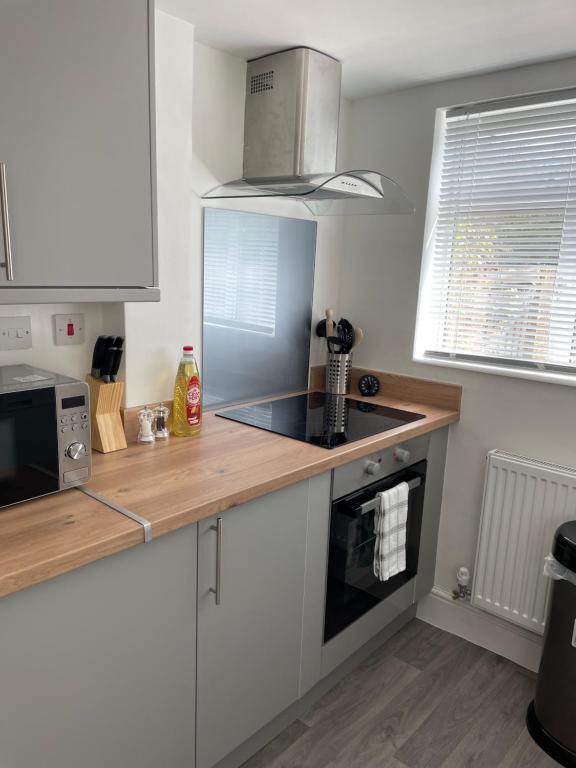 een keuken met witte kasten en een aanrecht bij House for Contractors and Families in Aldershot