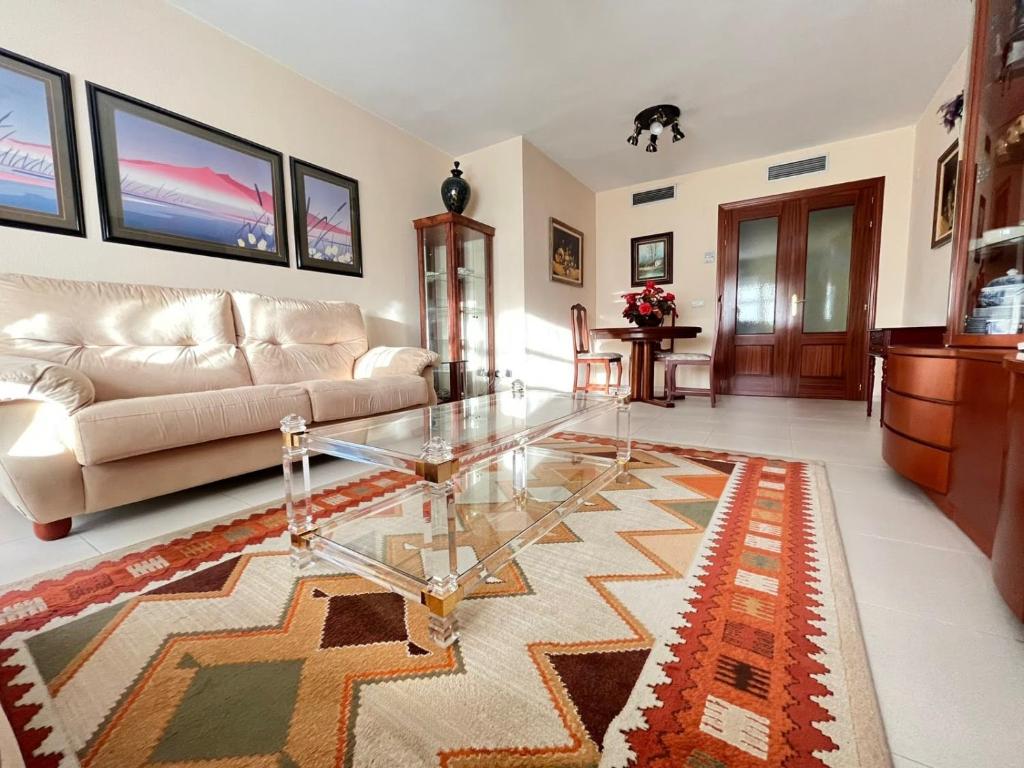 ein Wohnzimmer mit einem Glastisch und einem Sofa in der Unterkunft Teatinos Paradise in Málaga