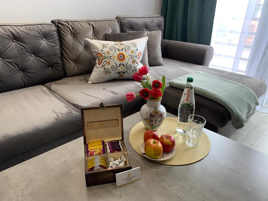 uma sala de estar com um sofá e uma mesa com frutas e legumes em Przy Złotych Piaskach em Sława