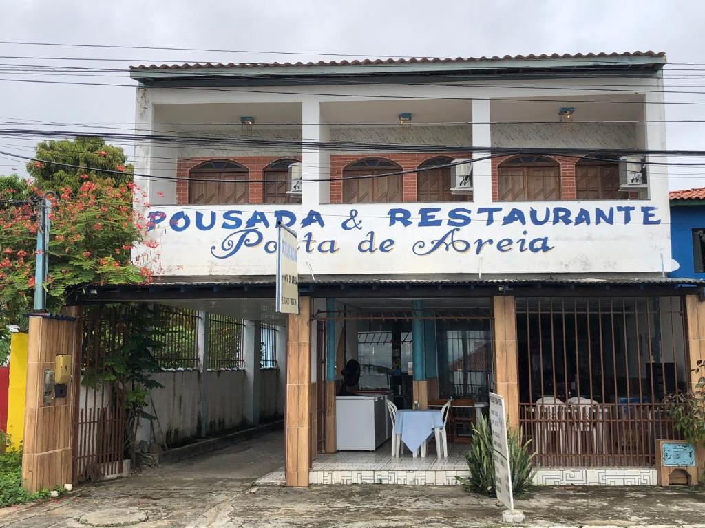 un restaurant avec un panneau à l'avant d'un bâtiment dans l'établissement Pousada Ponta de Areia, à Itaparica Town