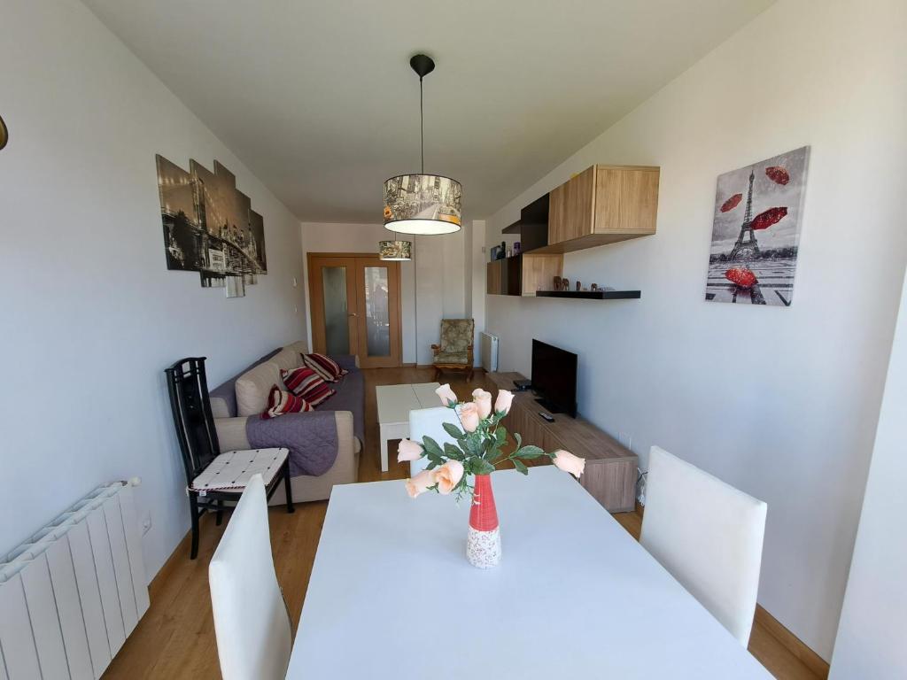 uma sala de estar com uma mesa branca com um vaso de flores em Apartamento en Badames em Bádames