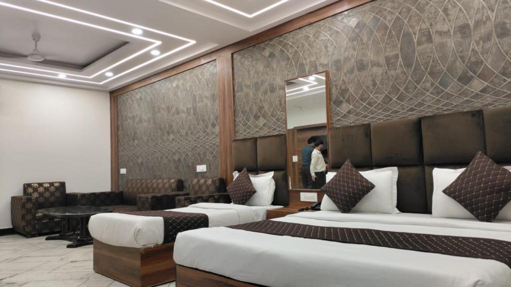 Pokój hotelowy z 2 łóżkami i lustrem w obiekcie HOTEL SINGH CONTINETAL w Nowym Delhi