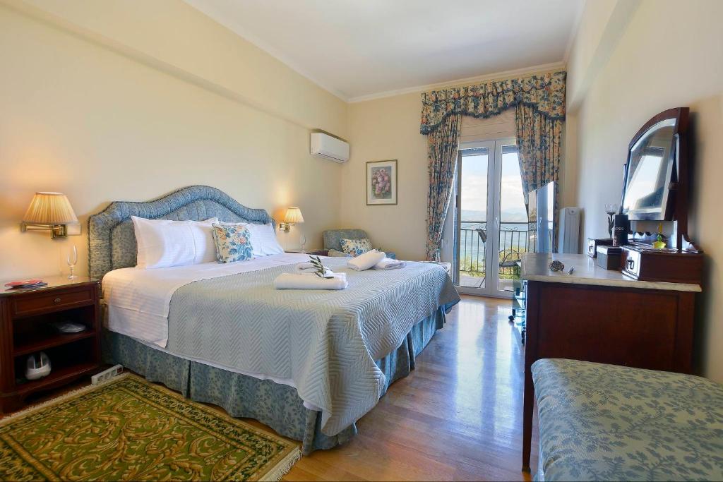 a hotel room with a bed and a balcony at Corfu Ionian Blue in Anemómylos