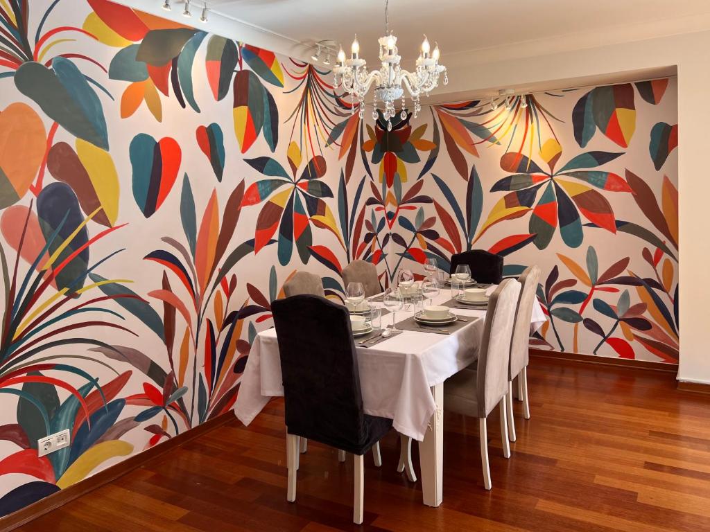 a dining room with a table and a colorful wall at Secure, Spacious, and Eclectic 1 to 3 Bedroom Apartments w Pool, Garden, Private Parking, Tennis Basketball Football Courts and Concierge close to Istinye Park, Turkish Tennis Federation, and Acibadem Maslak in Istanbul