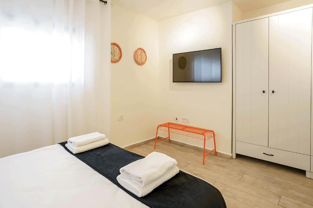 a bedroom with a bed and a tv on the wall at YalaRent Cliff side villa with private pool in Eilat