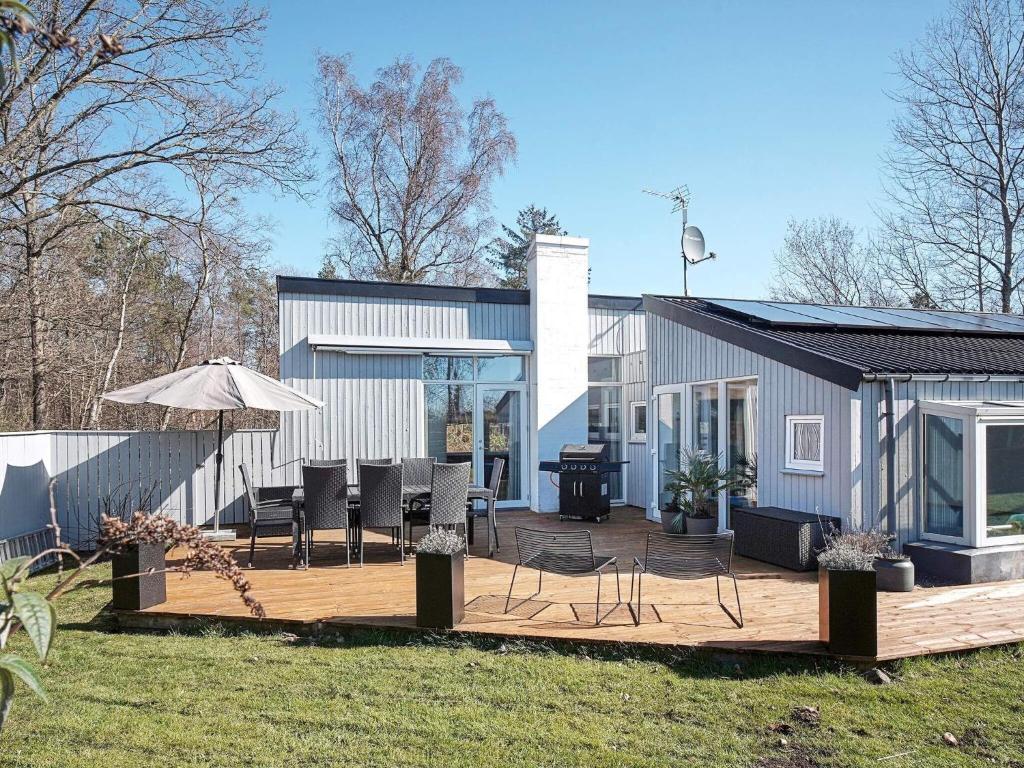 Casa con terraza con sillas y sombrilla en 8 person holiday home in Nex en Neksø