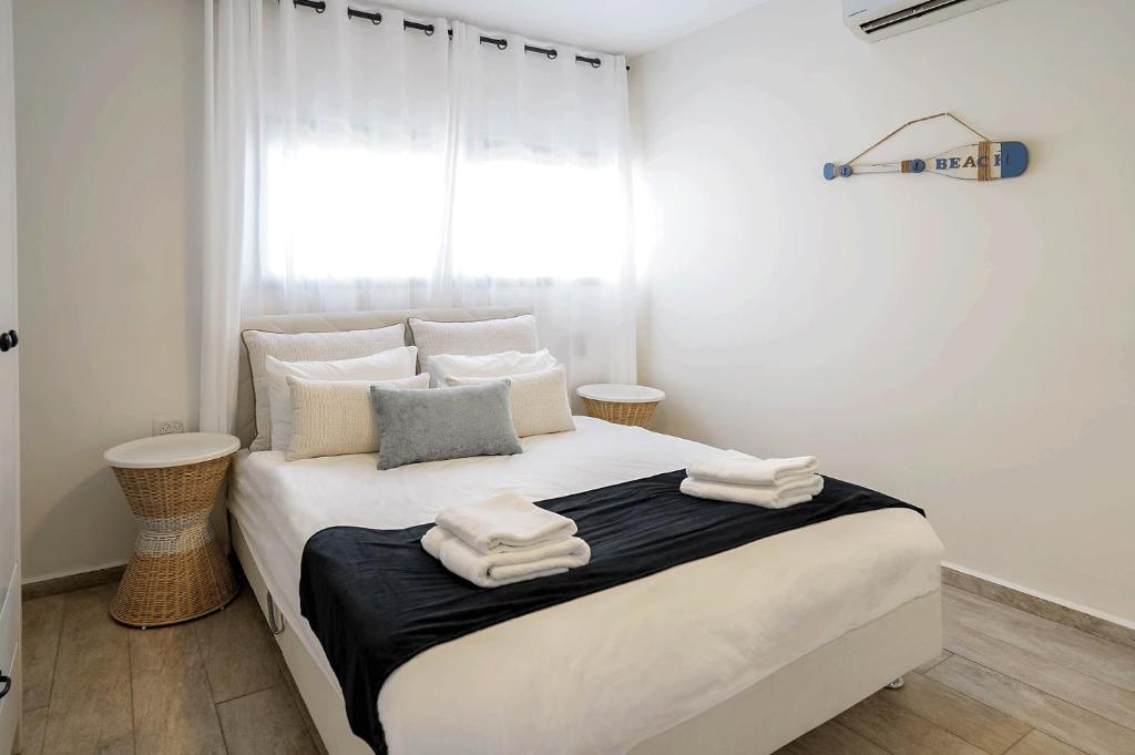 a bedroom with a large white bed with towels on it at YalaRent Cliff side villa with private pool in Eilat