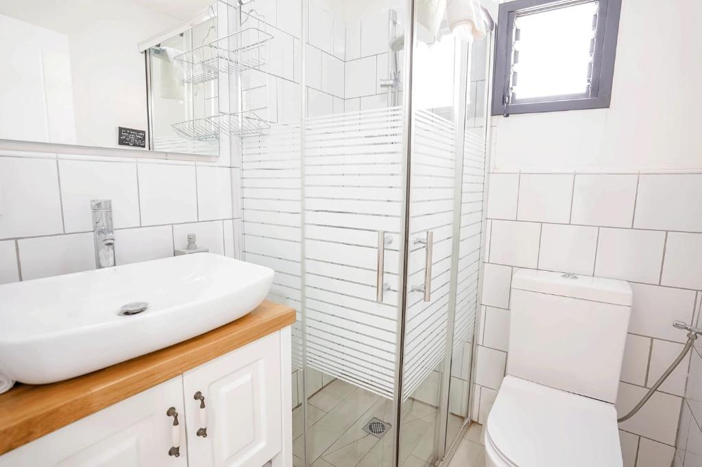 a white bathroom with a sink and a toilet at YalaRent Cliff side villa with private pool in Eilat