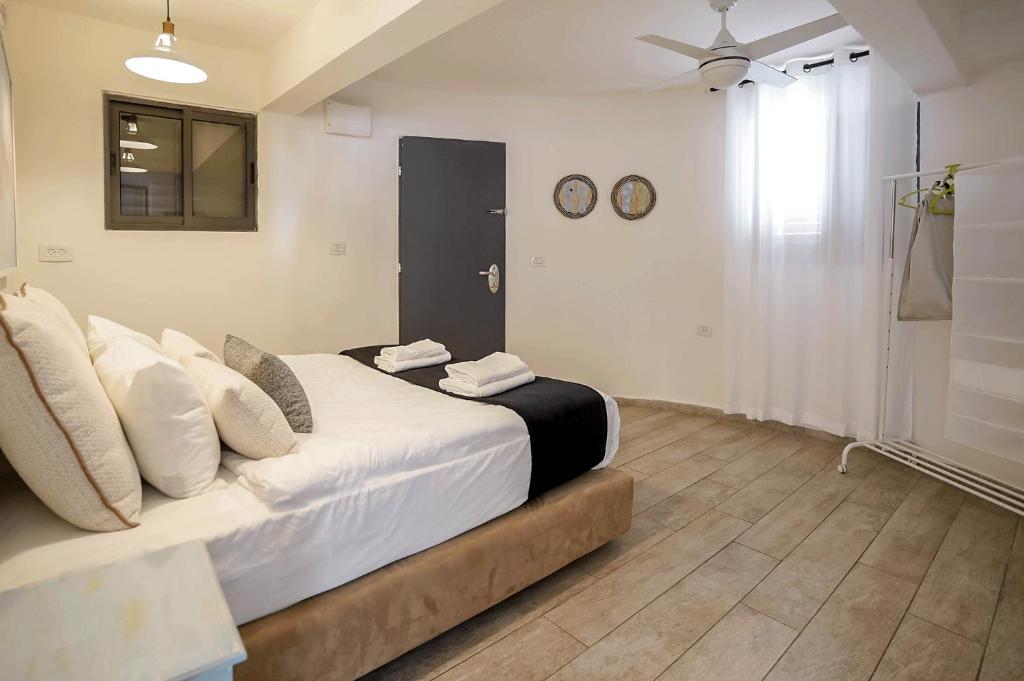 a bedroom with a large bed with two clocks on the wall at YalaRent Cliff side villa with private pool in Eilat