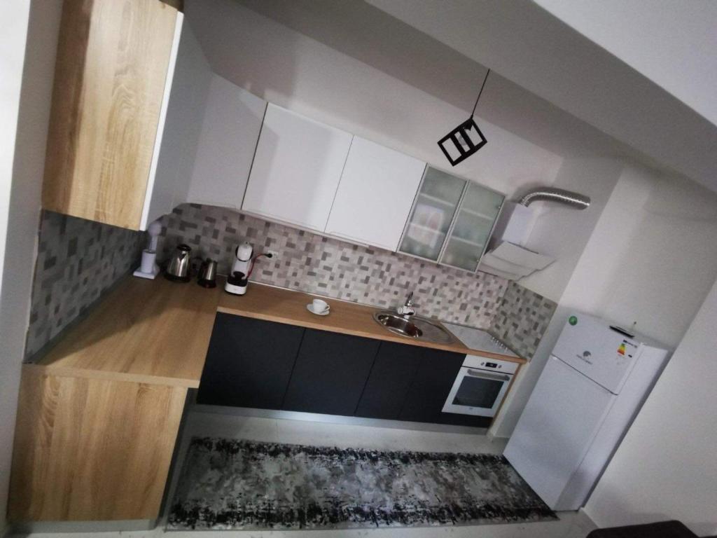 a small kitchen with a sink and a refrigerator at Tea Apartment in Kumanovo