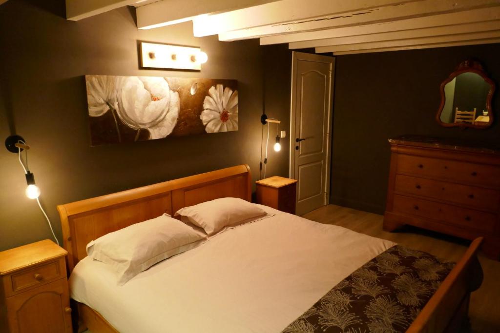 1 dormitorio con 1 cama y una pintura en la pared en Au coquelicot : gîte cosy pour 8 pers. avec jardin, en Ath