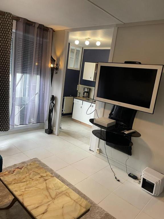 een woonkamer met een flatscreen-tv aan de muur bij A 2 pas de la gare in Chalon-sur-Saône