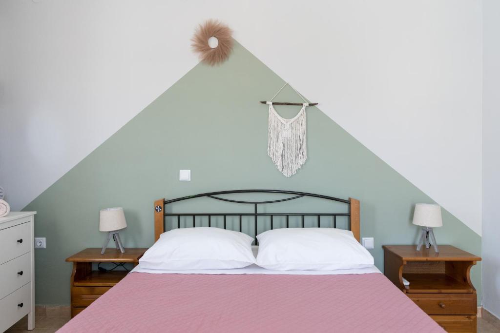a bedroom with a bed with a pink blanket and two night stands at The City Apartment in Lixouri
