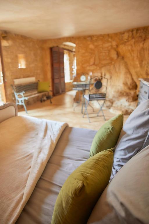 a large bed in a room with a stone wall at Domaine de Cantegrel - Gîtes de Charme et Suite Troglodyte en Périgord in Vitrac