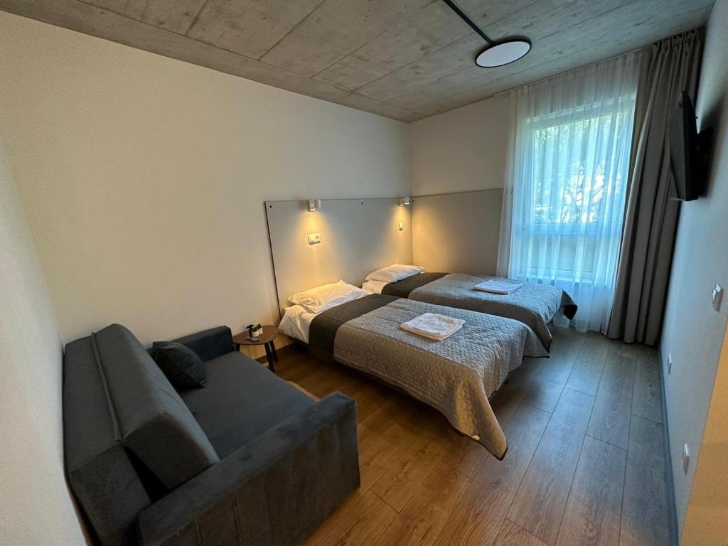 a living room with two beds and a couch at Tilzes Studio apartaments, Self check-in, Free parking, Comfort in Klaipėda