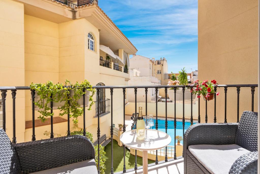 a balcony with chairs and a table and a pool at Beautiful duplex apartment in Fuengirola in Fuengirola
