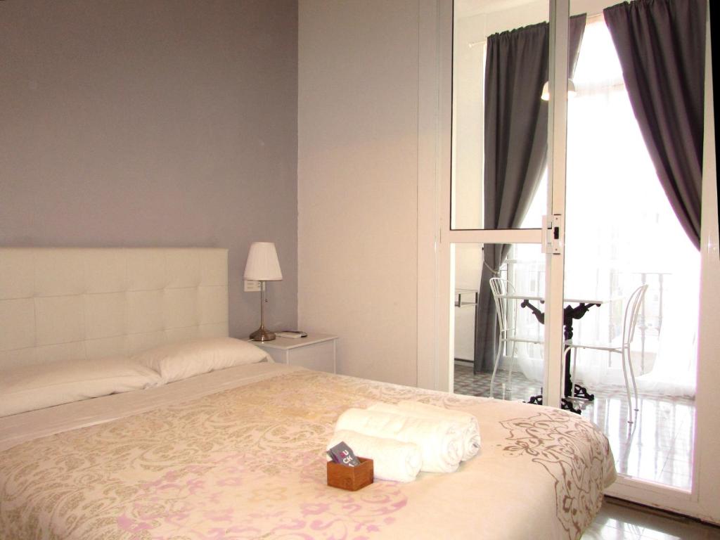 - une chambre avec un lit et une boîte de serviettes dans l'établissement Pensió Cerdanya, à Barcelone