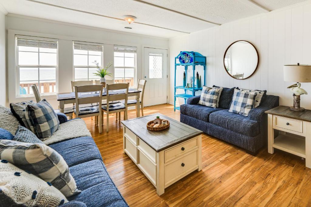 a living room with a blue couch and a table at Beachfront Emerald Isle Vacation Rental with Deck! in Emerald Isle