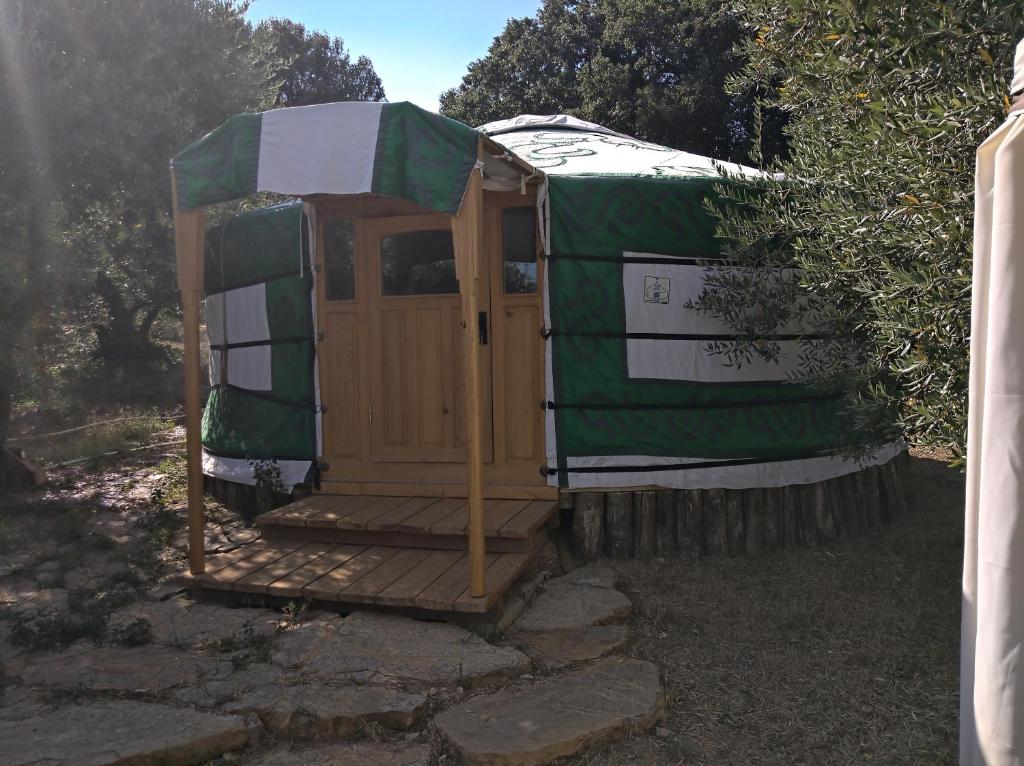 Casa verde y blanca con puerta de madera en Yurta Agricamping Villamagra, en Santa Luce