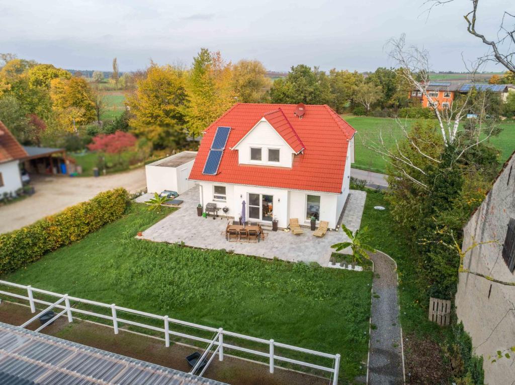 una piccola casa con un tetto rosso su un cortile di Reiterhof Kronwitter a Mainbernheim