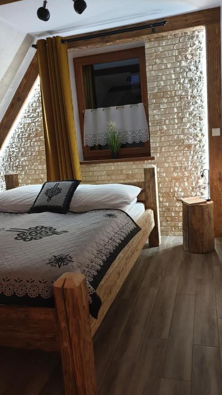 um quarto com uma cama e uma parede de tijolos em Stylowy Apartament I em Poronin