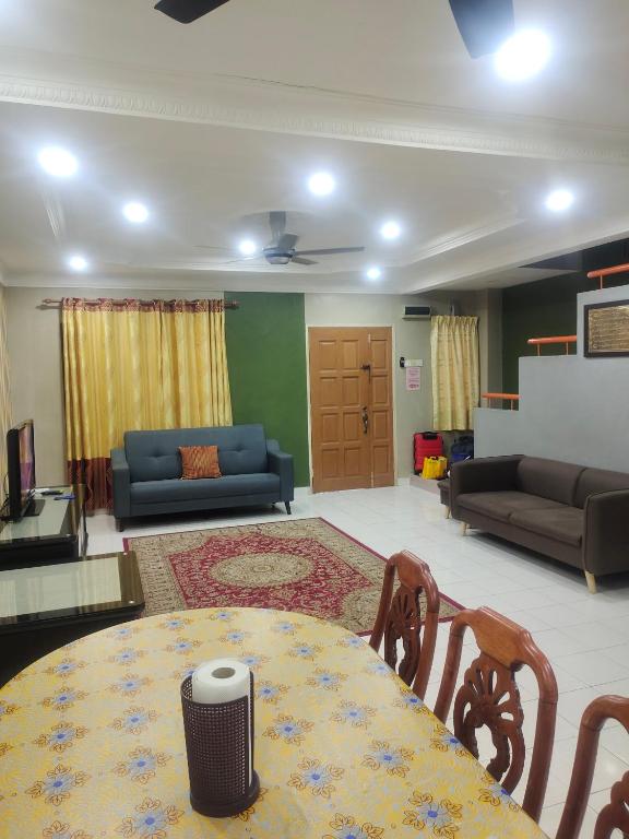 sala de estar con mesa y sofá en Homestay Cikgu Zedi Hulu Langat en Hulu Langat