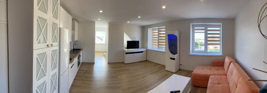 Una sala de estar con un sofá y un televisor. en Centro apartamentai, en Kalvarija