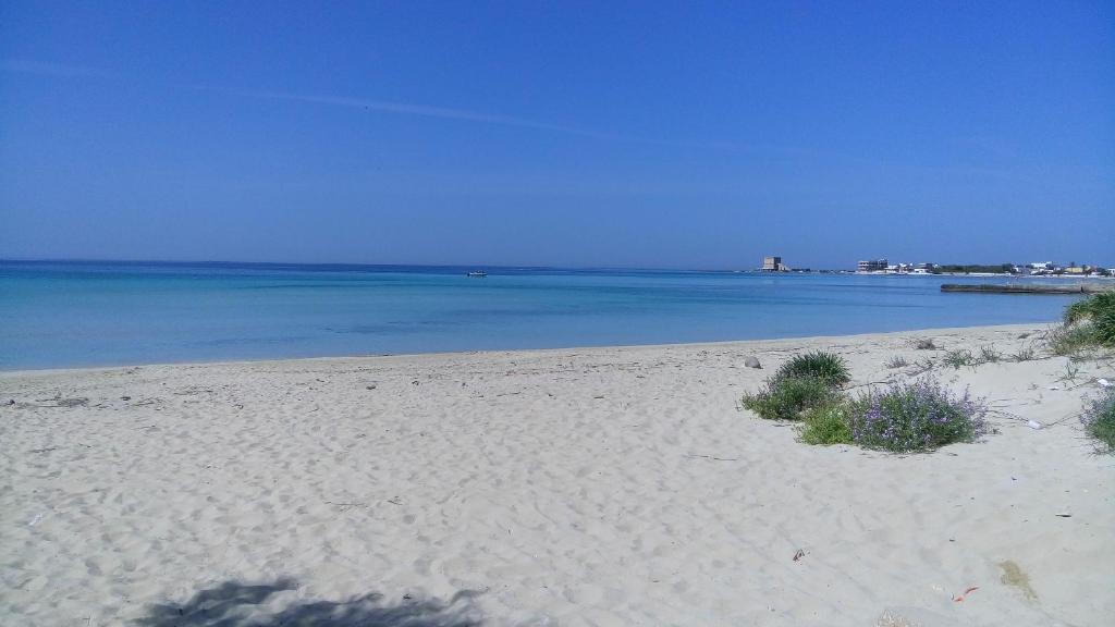 a sandy beach with the ocean in the background at Villetta Mira in Torre Lapillo