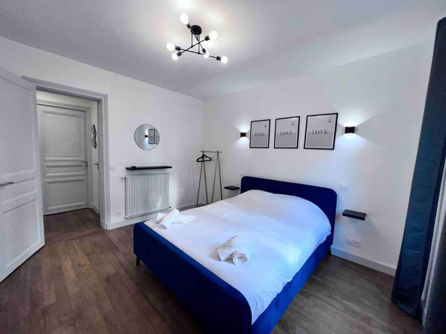 a bedroom with a blue and white bed and a fireplace at Paris 18 - 6P - 2BR - Appartement cosy moderne équipé in Paris