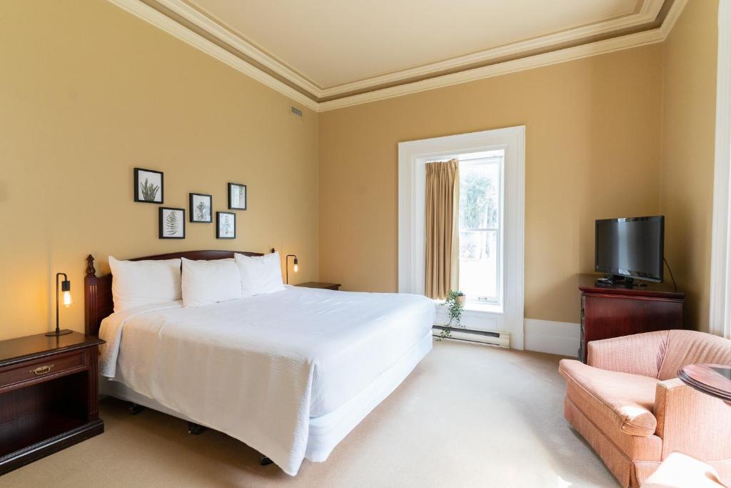 um quarto com uma grande cama branca e uma janela em Westover Inn em Saint Marys