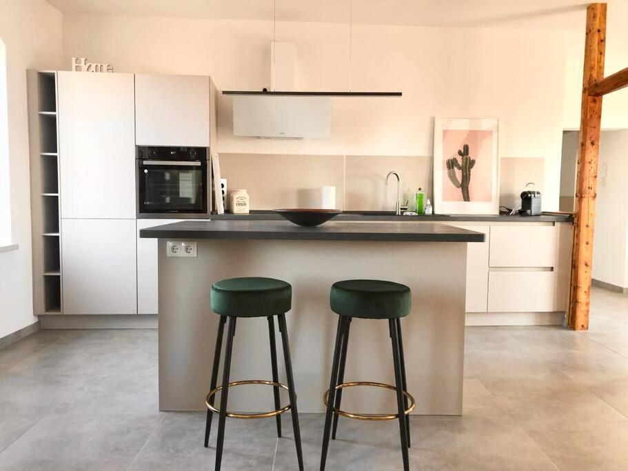 a kitchen with two green stools at a counter at An der Stadtmauer Bürgel in Bürgel