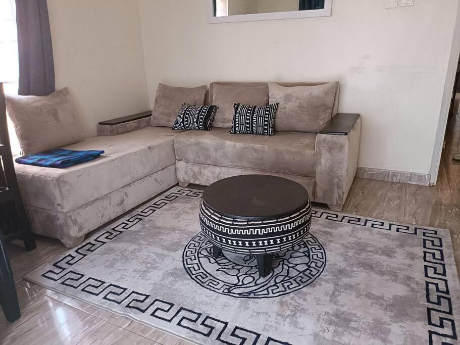 a living room with a couch and a table at Amaryllis homes , within city centre,near River Nile in Jinja
