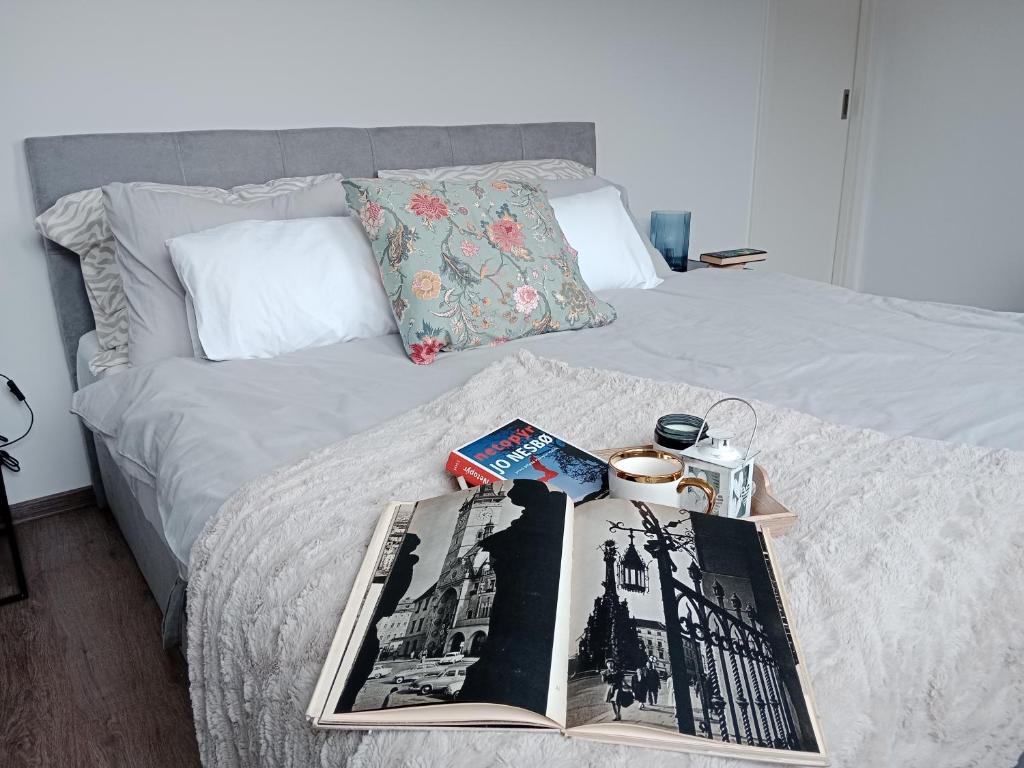 a bed with a book and magazines on it at J&Z apartmán in Olomouc