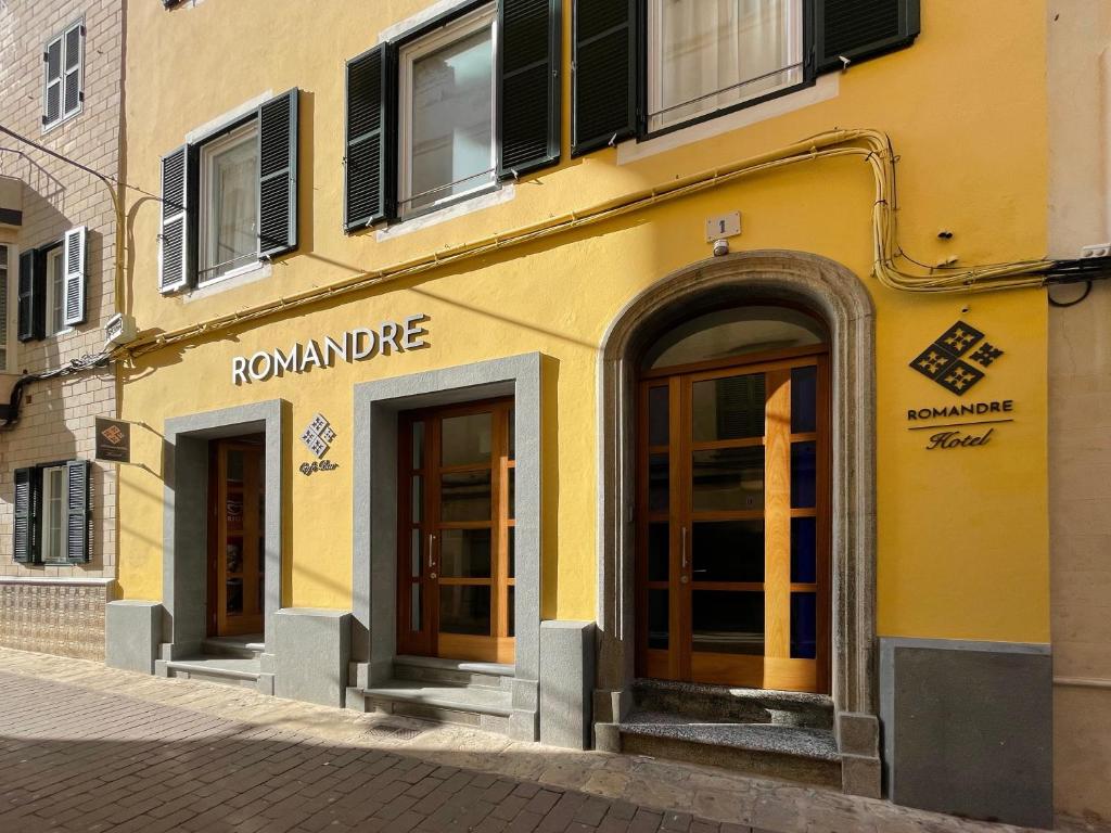ein gelbes Gebäude mit zwei Türen auf einer Straße in der Unterkunft ROMANDRE in Alaior