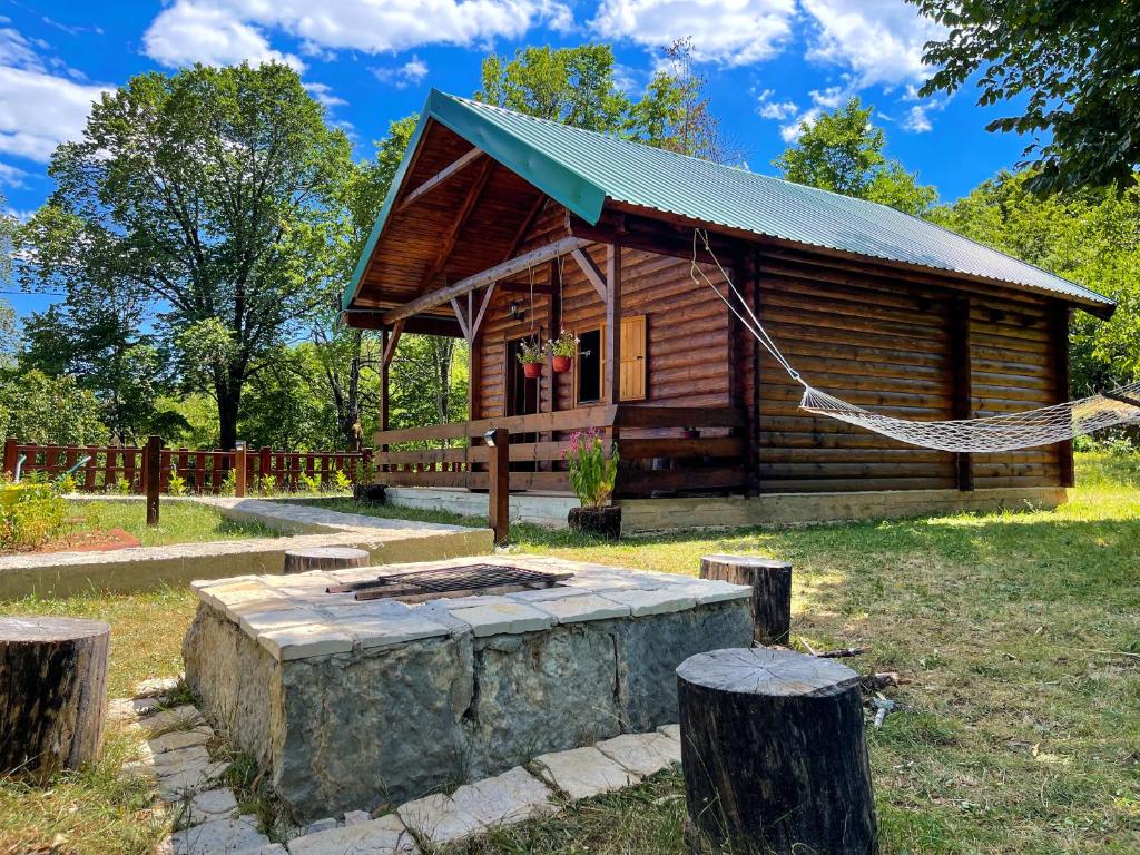 a log cabin with a hammock in front of it at Cabin House Dubovik in Cetinje