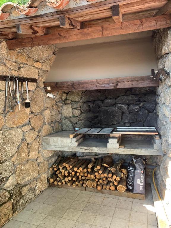 a stone oven with a pile of fire wood at Gîte Framboisier au Château des Pauses in Saint-André-de-Majencoules