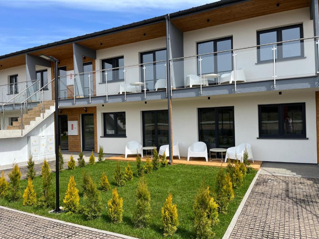 an apartment building with a balcony with chairs and tables at Apartamenty Dębina 300m do plaży in Debina