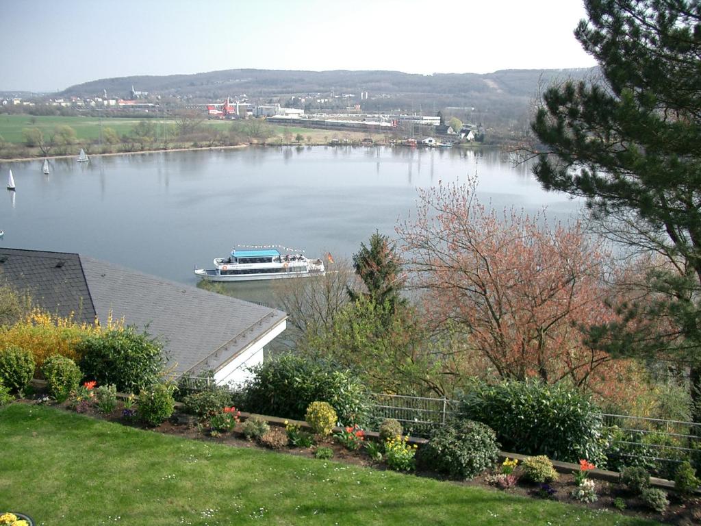 a boat on a lake with a house at Apartment Seeblick Wetter in Wetter