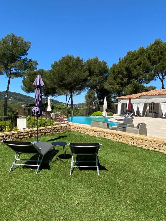 un patio con 2 sillas, una mesa y una piscina en Une Pause en Provence, en Le Beausset