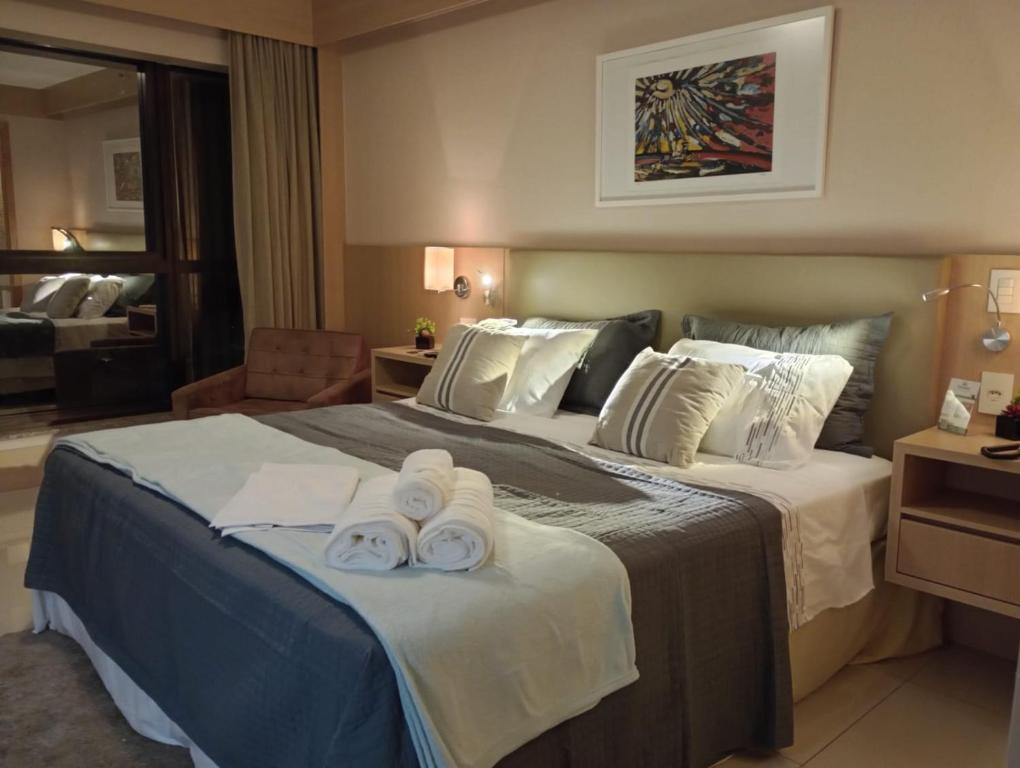 Una habitación de hotel con una cama con toallas. en Flat Premium Particular Cullinan Hotel en Brasilia
