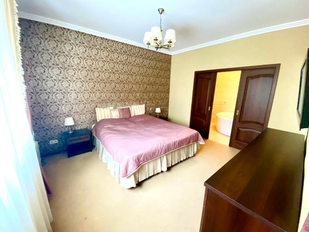 a bedroom with a bed with a pink comforter at Przy Dębach in Stargard