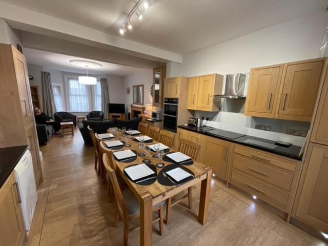 a kitchen with a long table in a room at Dog Friendly Town House in Paignton